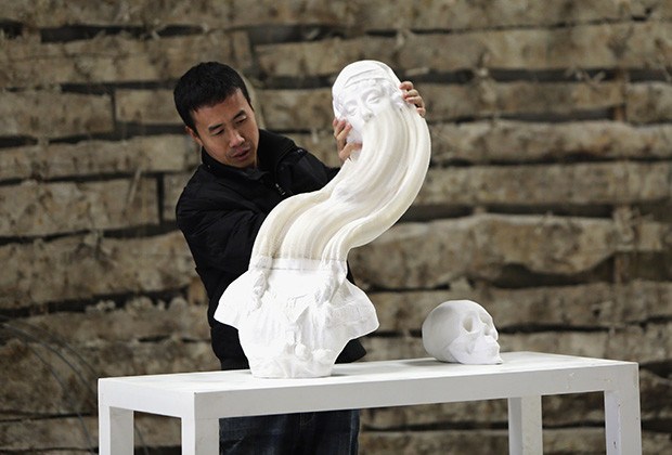 dpexpress-thiet-ke-Chinese artist Li Hongbo stretches a paper sculpture work on the outskirts of Beijing